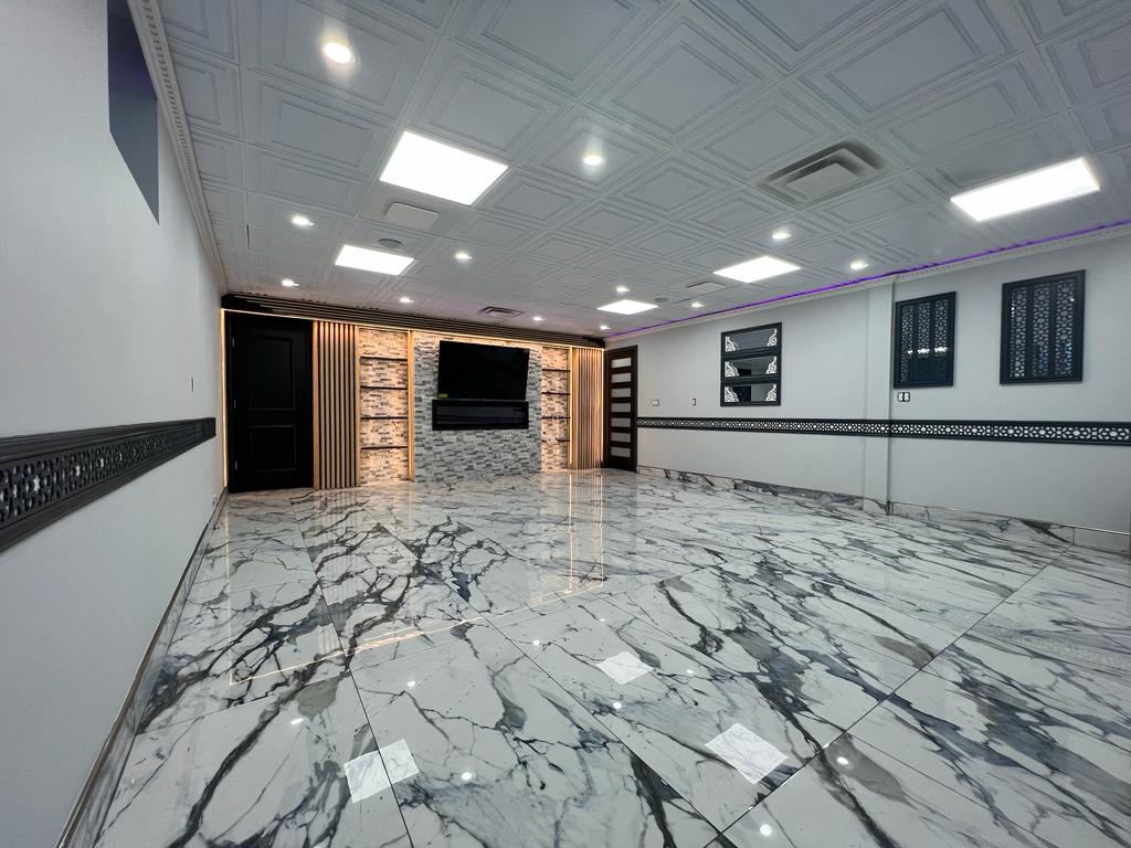 Basement after renovation with custom lighting and marble-style flooring