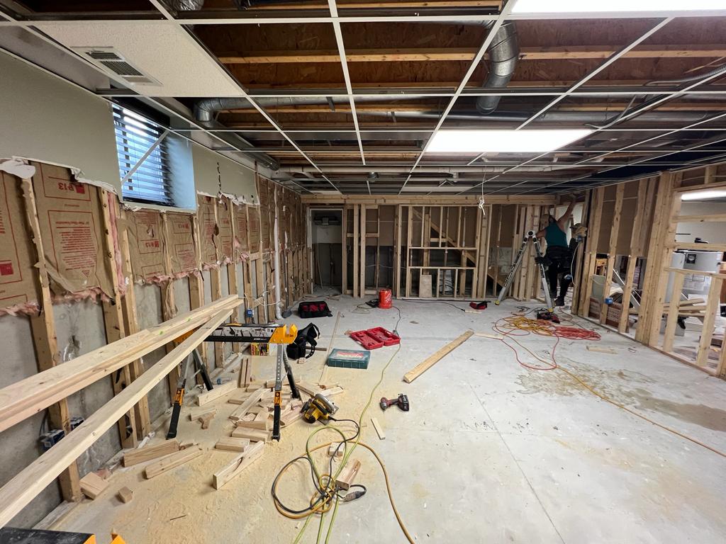 The same basement before renovation, stripped to the studs